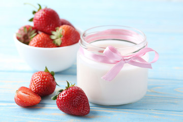 Strawberry yogurt in glass on wooden table