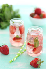 Fresh strawberry drink in bottle on wooden table