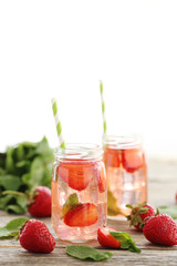 Fresh strawberry drink in bottle on wooden table