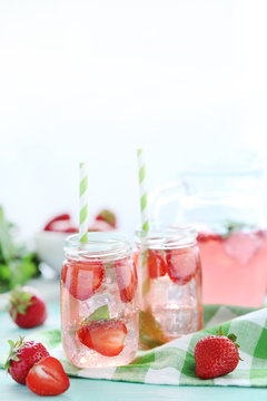 Fresh strawberry drink in bottle on wooden table