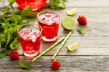 Fresh strawberry drink in glass with lime on wooden table