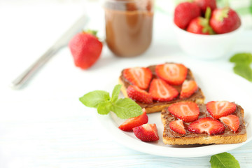 French toasts with chocolate and strawberry on wooden table