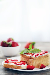 French toasts with cream cheese and strawberry on wooden table