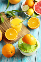 Citrus fruits with juicer on a blue wooden table