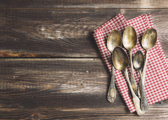 Naklejka premium Old spoons piled on rustic wooden background
