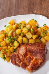 grilled meat fillet steak with fried potato in a plate on wooden table