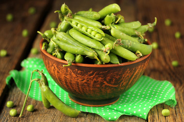 Closed pods of green peas in a bowl