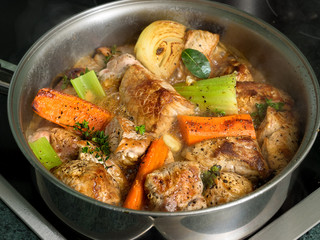 Roasted pork with herbs and vegetables in wine sauce
