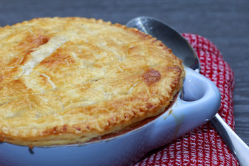 Chicken and bacon pot pie with cheese on wooden table
