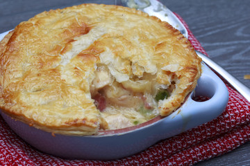 Chicken and bacon pot pie with cheese on wooden table