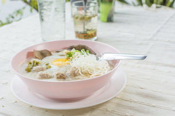 rice porridge, rice gruel or congee with pork, egg, liver,  delicious the traditional Chinese breakfast.