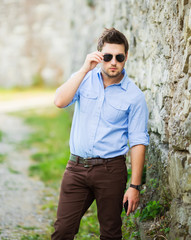 Outdoor portrait of modern young man watch on time in the street.