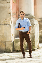 Obraz premium Urban business man talking on smart phone at walking. Handsome male model in his 20s.