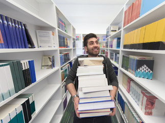 Student holding lot of books in school library