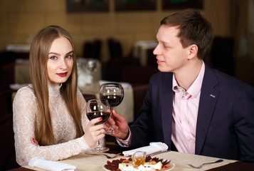 Couple toasting wineglasses in a luxury restaurant.
