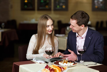Cheerful couple with menu in a restaurant.