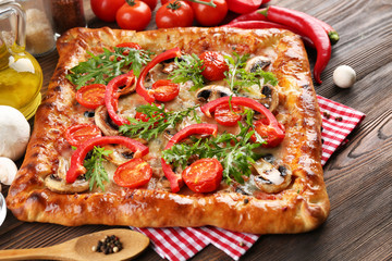 Freshly homemade pizza on wooden table closeup