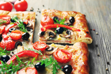 Freshly homemade pizza on wooden table closeup