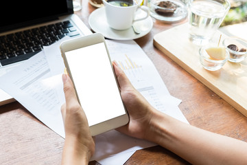 Close up of a woman using smart phone with blank mobile and cup