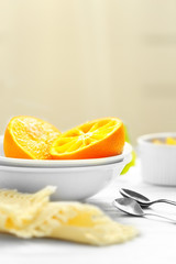 Eating oranges with spoon on white table