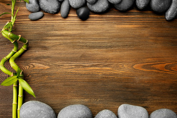 Spa stones and bamboo sticks on wooden background