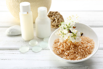 Spa treatment with blooming branch on white wooden table