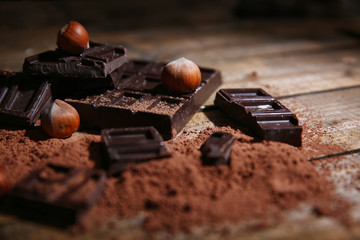 Slices of dark chocolate with nuts on table