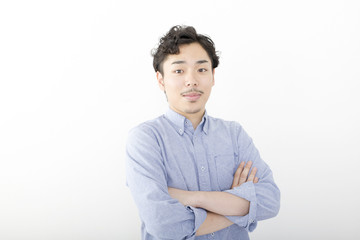 男性　ポートレート　カメラ目線　シリアス　真剣　白バック　髭　パーマ　オフィスカジュアル　腕組