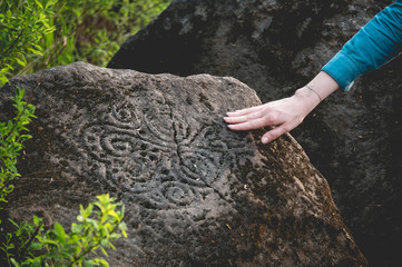 Ancient figures on a rock with his hand Girl