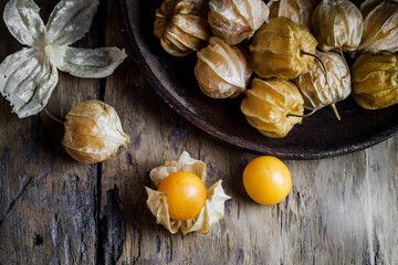 Closeup orange organic cape gooseberries on wooden background