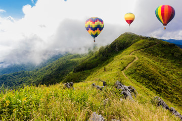 Colorful hot-air balloons flying over the mountain at Pha Tung,Chiangrai province ,North of Thailand.