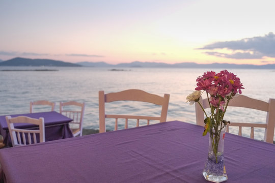 Purple table with sea views during sunset, in Aegina, Greece
