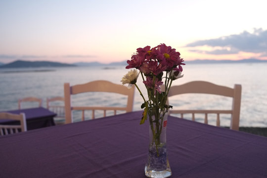Purple table with sea views during sunset, in Aegina, Greece