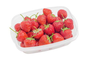 Garden strawberry fruits in the plastic tray on light background
