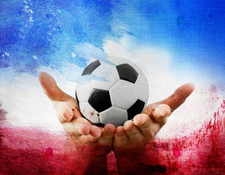 Hands holding football on France's flag colored background