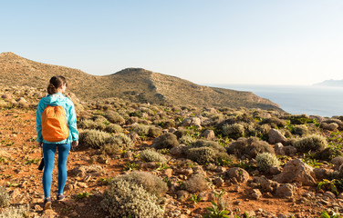 Young tourist woman in Greece looking at a beautiful landscape