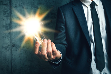 Business creativity concept with businessman holding light in ha