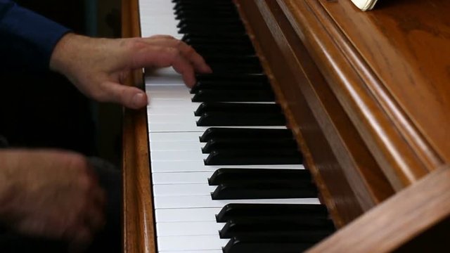 Older Male Hands Playing Slowly On Piano
