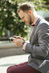 Businessman using digital tablet sitting on bench in a park