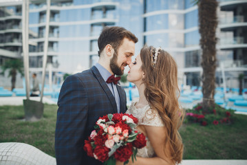 Elegant beautiful couple posing near modern glass building