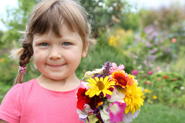 little girl with flowers in the garden