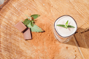A smoothie with cacao and mint, milkshake on wooden table,