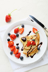 hot crepes with berries and sauce