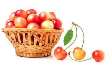 yellow cherries in a wicker basket isolated on white background