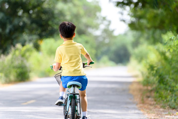 Naklejka premium Boy riding bicycle on the road.