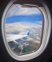 Fototapeta premium Clouds and sky as seen through window of an aircraft