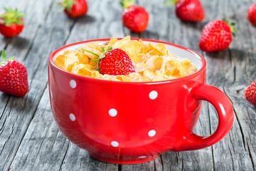 corn flakes with milk and strawberries, close-up