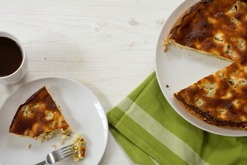 cake or pie with rhubarb, whole and serving on white wood, view from above