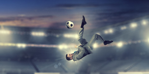 Businessman kicking ball