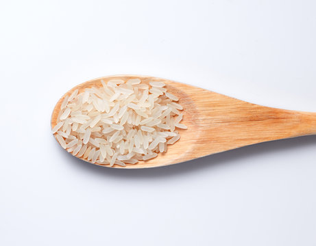 rice in a wooden spoon on a white background